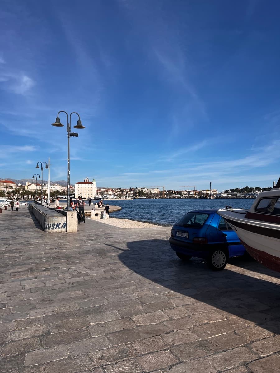 Splitska Riva — palme, kamen i Jadrolinija u luci